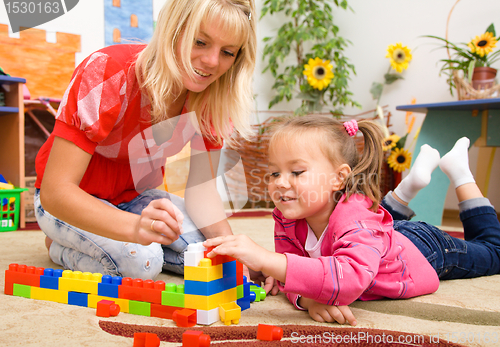 Image of Teacher and child are playing with bricks