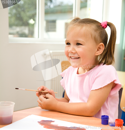 Image of Little girl is play with paints