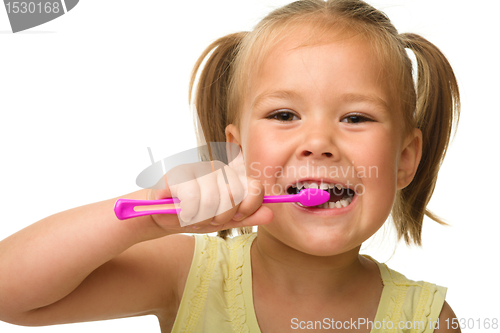 Image of Little girl is cleaning teeth using toothbrush
