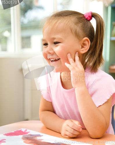 Image of Little girl is play with paints