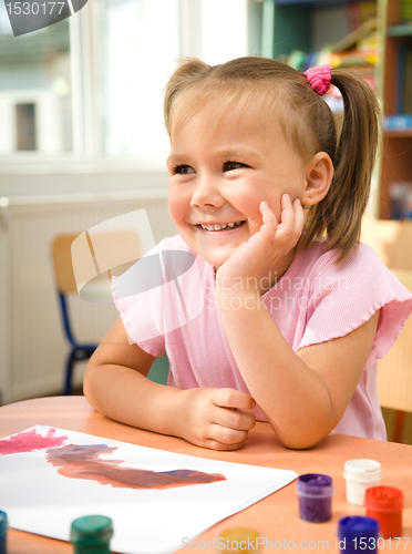 Image of Little girl is play with paints