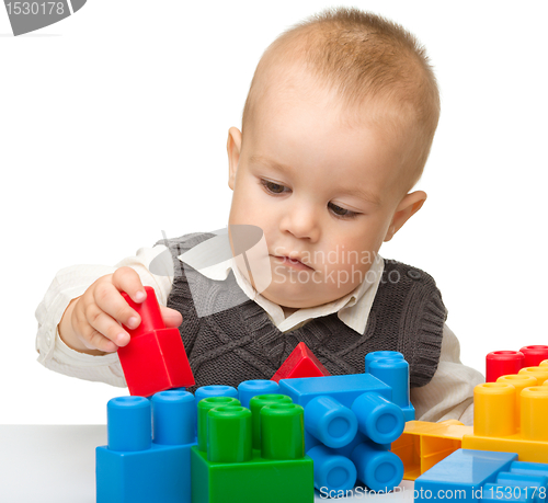 Image of Little boy plays with building bricks