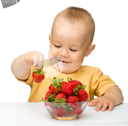 Image of Happy little boy with strawberries