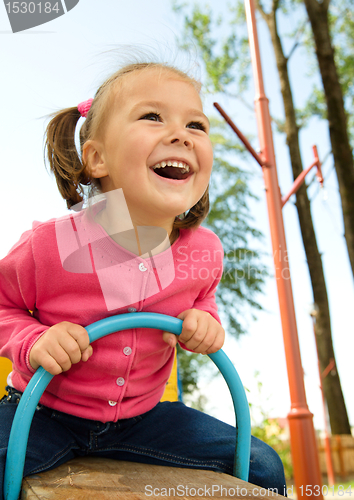 Image of Cute little girl is swinging on see-saw