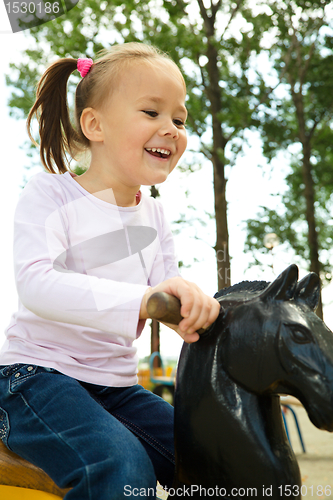 Image of Cute little girl is swinging on see-saw