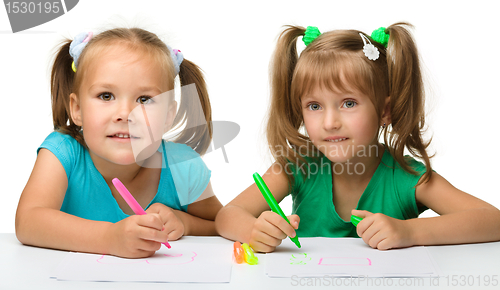 Image of Two little girls draw with markers