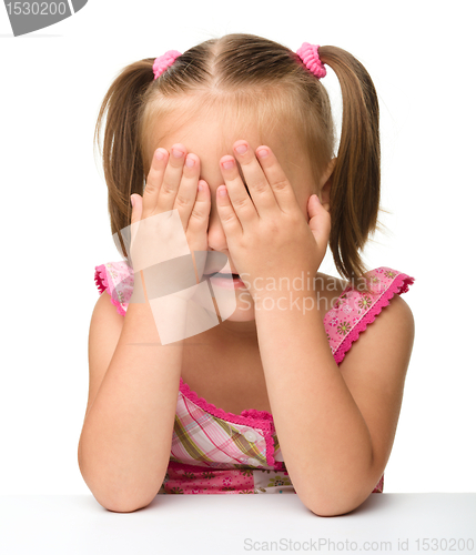 Image of Little girl is playing hide-and-seek