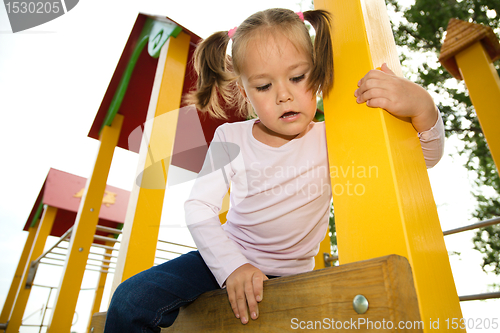 Image of Little girl is playing in playground