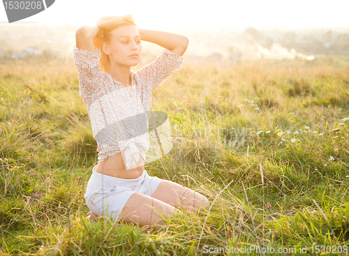 Image of Girl is relaxing on green field