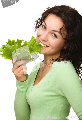 Image of Beautiful young girl with green lettuce leaf