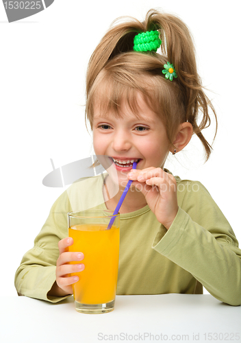 Image of Cute little girl is drinking orange juice