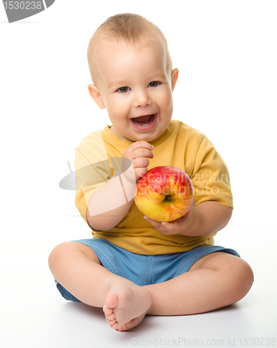 Image of Cheerful little boy with red apple