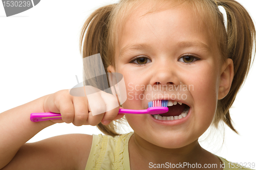 Image of Little girl is cleaning teeth using toothbrush