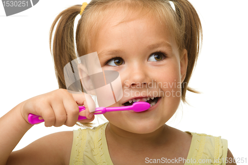 Image of Little girl is cleaning teeth using toothbrush