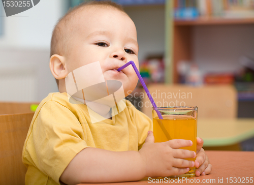 Image of Little boy is drinking orange juice