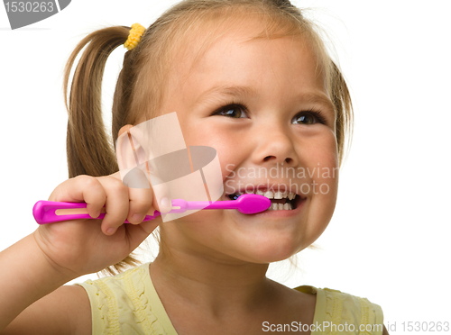 Image of Little girl is cleaning teeth using toothbrush