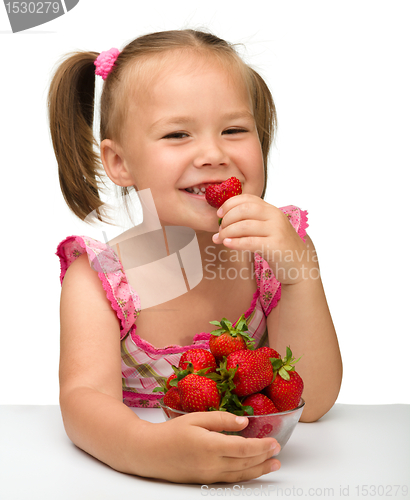 Image of Happy little girl eats strawberries