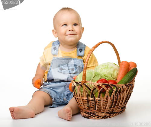Image of Cute little boy with basket full of vegetables