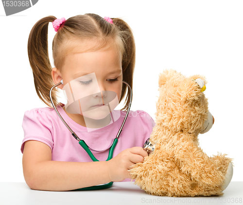 Image of Little girl is playing with her teddy bear