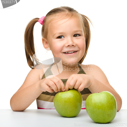 Image of Little girl with two green apples