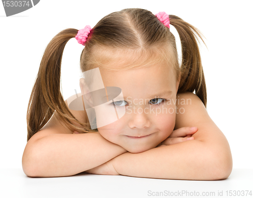 Image of Cute little girl is sitting at the table