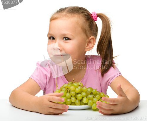 Image of Little girl is eating grapes