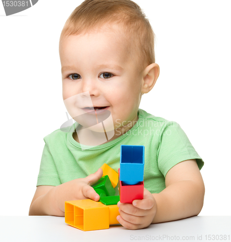 Image of Little boy plays with building bricks