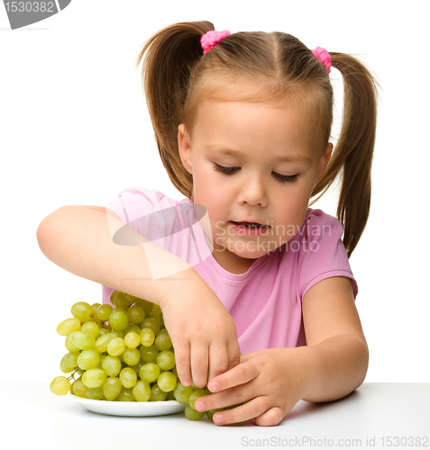 Image of Little girl is eating grapes
