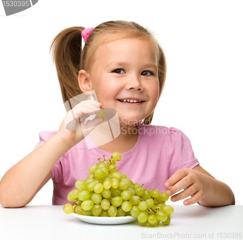 Image of Little girl is eating grapes