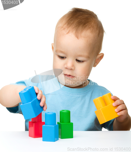 Image of Little boy plays with building bricks