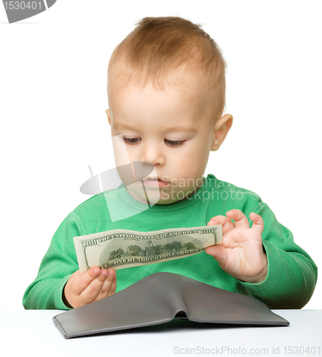 Image of Cute little boy is counting money