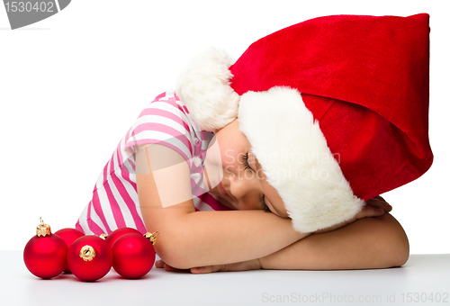 Image of Cute little girl is sleeping wearing santa hat