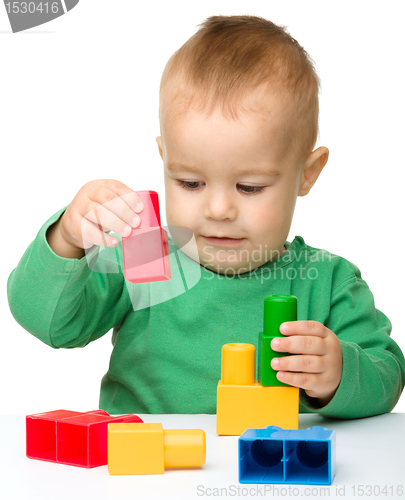 Image of Little boy plays with building bricks