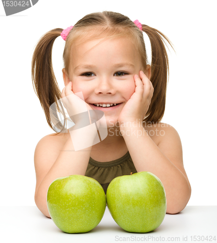 Image of Little girl with two green apples