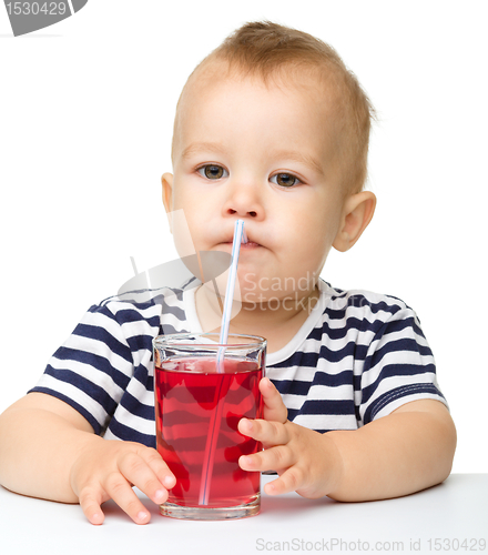 Image of Cute little boy is drinking red juice