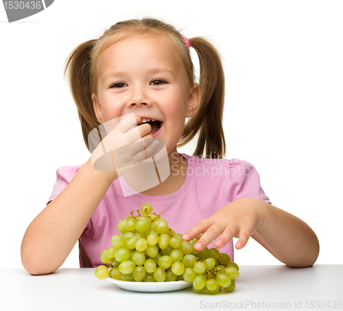 Image of Little girl is eating grapes