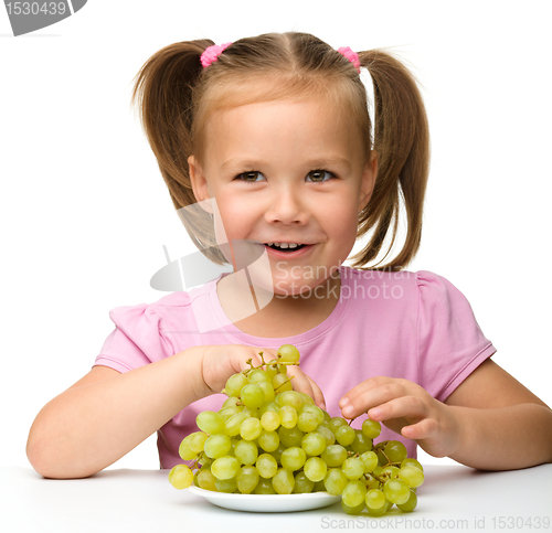 Image of Little girl is eating grapes