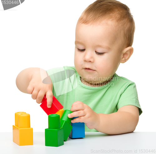 Image of Little boy plays with building bricks