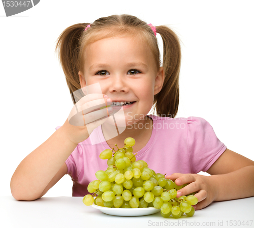Image of Little girl is eating grapes