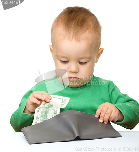 Image of Cute little boy is counting money