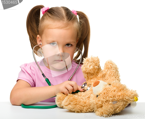 Image of Little girl is playing with her teddy bear