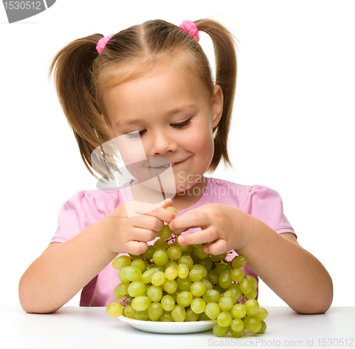 Image of Little girl is eating grapes