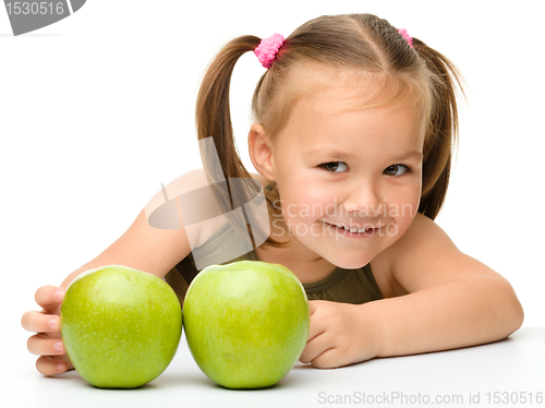 Image of Little girl with two green apples