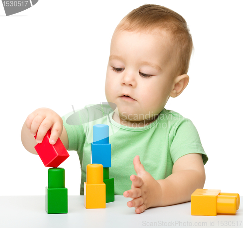 Image of Little boy plays with building bricks
