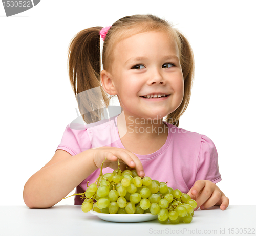 Image of Little girl is eating grapes