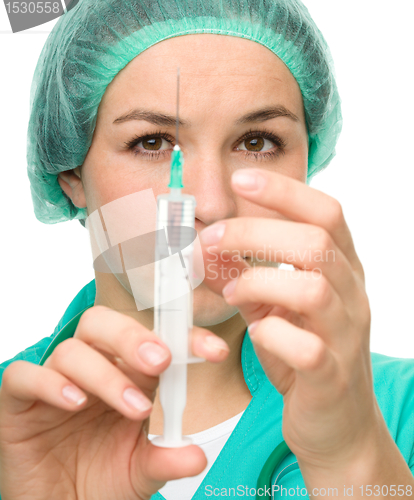Image of Young nurse is preparing syringe for injection