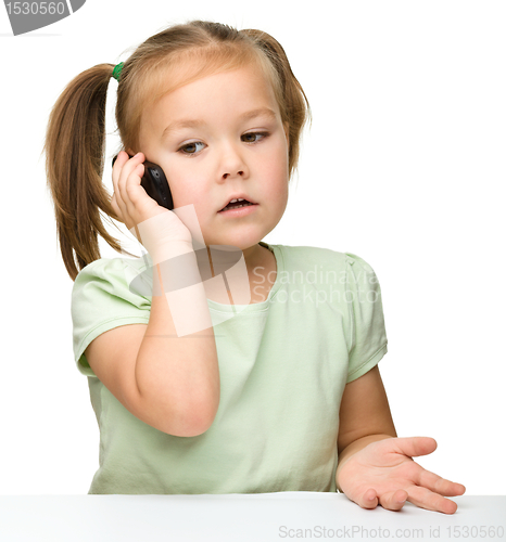 Image of Cute little girl is talking on a cell phone