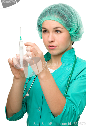 Image of Young nurse is preparing syringe for injection