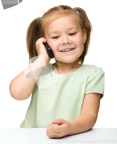 Image of Cute little girl is talking on cell phone