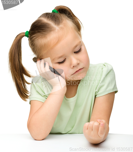 Image of Cute little girl is talking on a cell phone